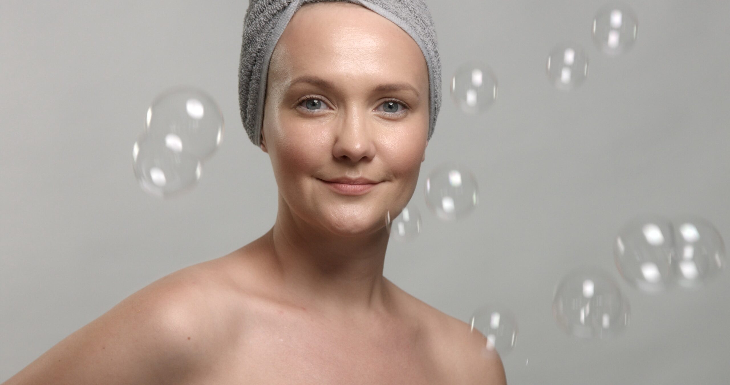 A woman in her 30s or 40s with radiant, firm skin receiving a non-invasive skin tightening treatment (like RF microneedling or Morpheus8) in a sleek, modern med spa setting. The provider wears professional attire and gently uses a handheld device on the woman’s jawline or cheek. Natural sunlight streams in through a window, with subtle tropical elements like palm shadows or soft greenery to reflect Florida's ambiance. The vibe is clean, luxurious, and confident. Text overlay: “Non-Surgical Skin Tightening in Florida